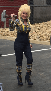 Dolly Parton holding an axe dressed as a lumberjack